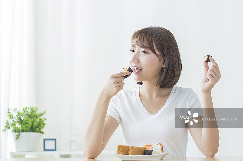 年轻女人吃寿司图片素材