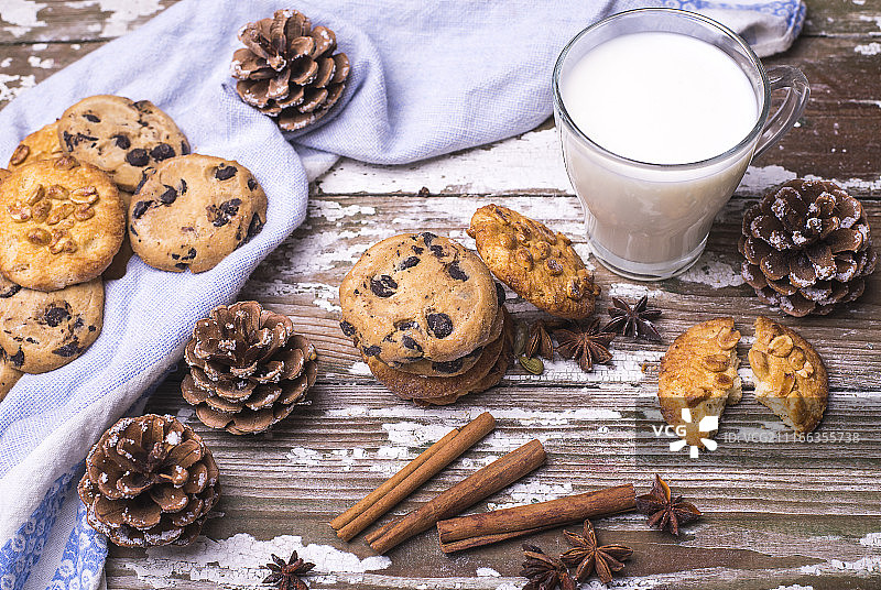 为圣诞老人新鲜烘焙的天然饼干与一杯牛奶在一个木制的背景。图片素材