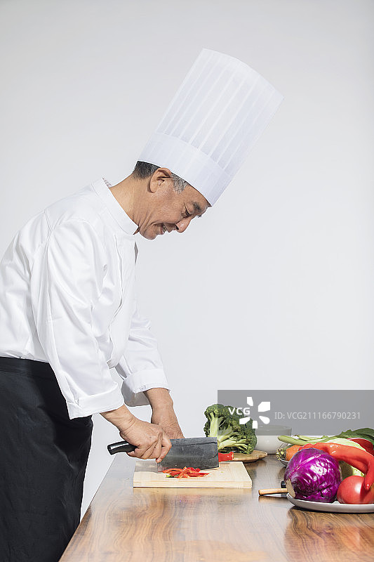 一个老年厨师正在切菜图片素材