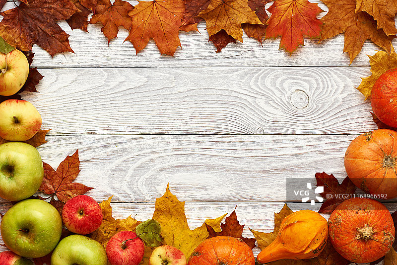 秋天的叶子，苹果和南瓜在旧的木制背景与复制空间图片素材