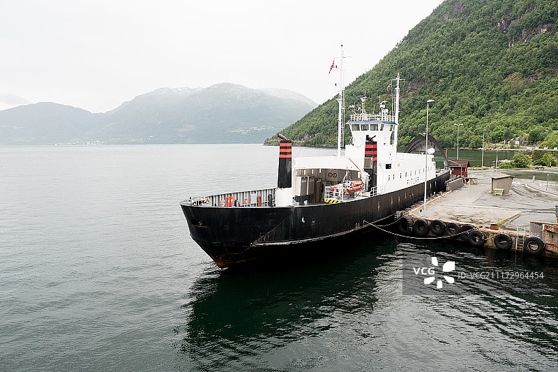 挪威峡湾上的船，背景是山脉图片素材