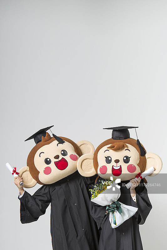 猴头男、女穿着毕业服装，手拿毕业证书和花束图片素材