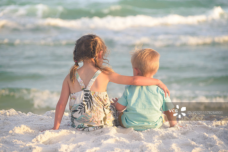 妹妹和弟弟在海滩上拥抱图片素材
