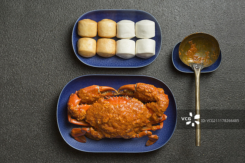 蓝色盘子里的炒蟹，灰色背景的中国饺子图片素材
