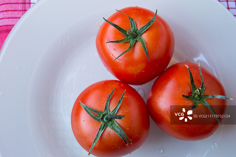 新鲜成熟的西红柿在白色的盘子上-俯视图图片素材