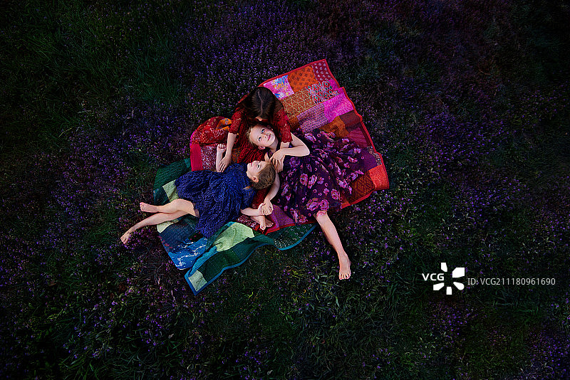 两个女孩躺在上的毯子上图片素材