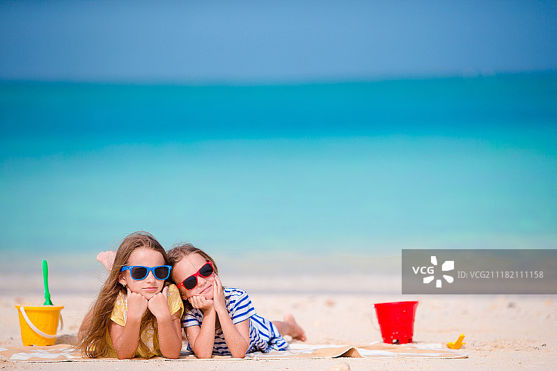 热带度假的小女孩玩海滩玩具图片素材