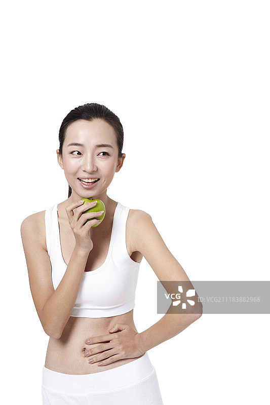 穿着运动服拿着苹果的女人的照片图片素材