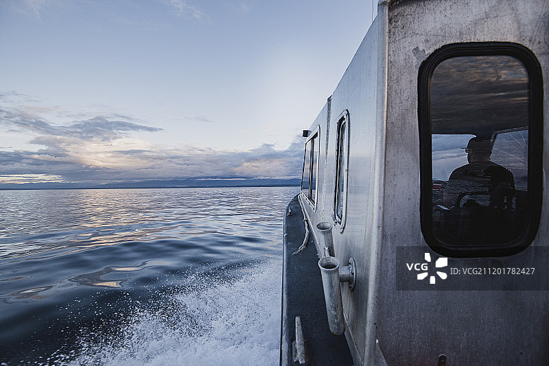 加拿大不列颠哥伦比亚省，坎贝尔河，船长在宁静的河上驾驶着船图片素材