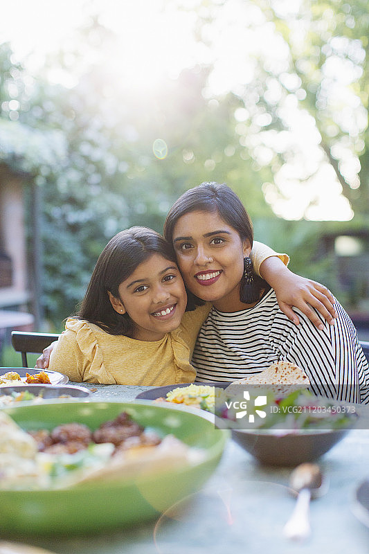 肖像快乐的母亲和女儿在餐桌上图片素材