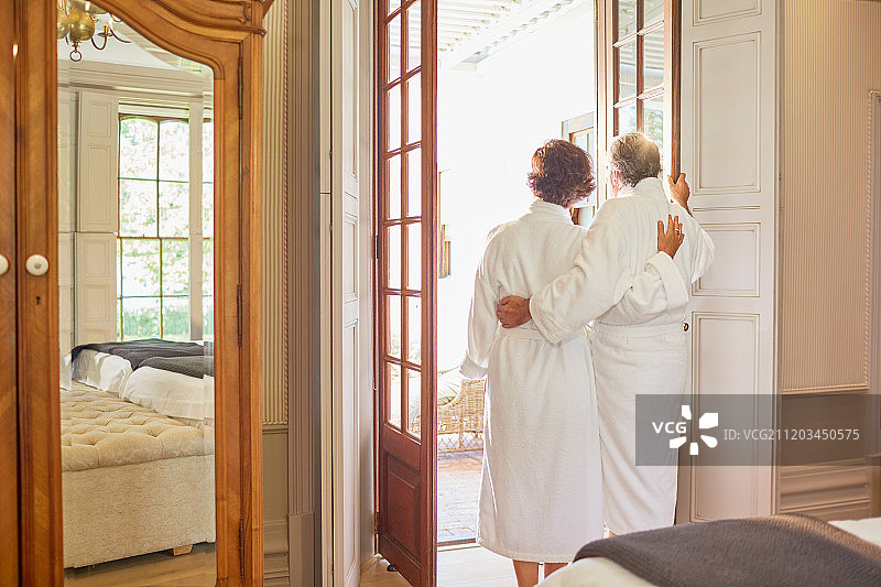 一对穿着spa浴袍的成熟夫妇站在酒店阳台门口图片素材