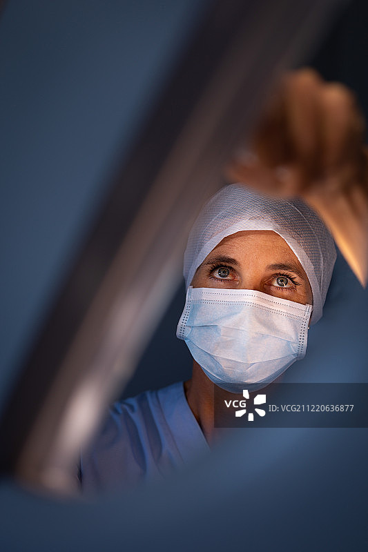 一个白人女性外科医生在医院修理手术灯的特写图片素材