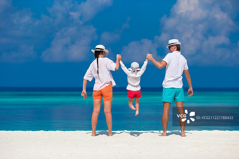 一个年轻的家庭在白沙滩上度过暑假图片素材