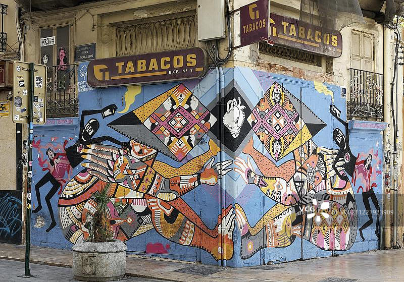 由色彩鲜艳的装饰物组成的人物连在一起，由瓦伦西亚街头艺术艺术家disney ylexya绘制的墙壁，西班牙瓦伦西亚的老城El Carme图片素材