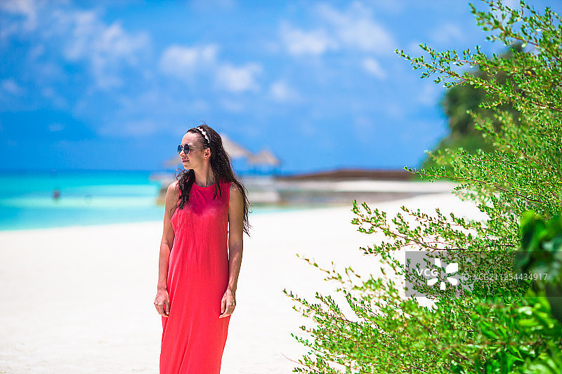 年轻快乐的女人在白色的沙滩上图片素材