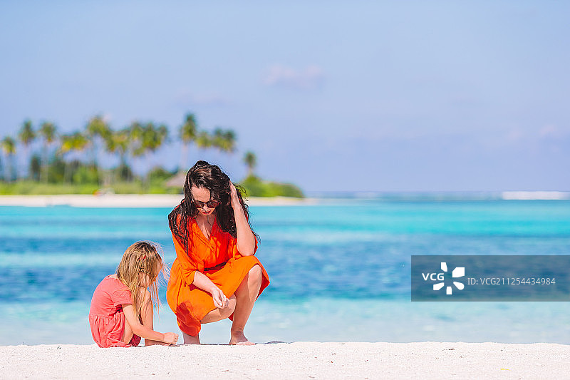 母亲和女儿在热带海滩享受时光图片素材