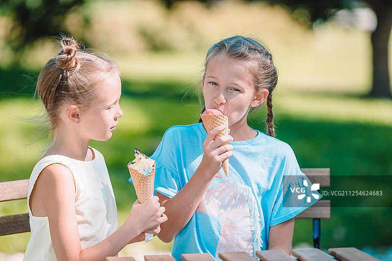 夏天在户外咖啡馆吃冰淇淋的小女孩图片素材