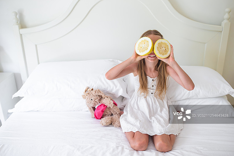 小女孩用半个柠檬遮住眼睛图片素材