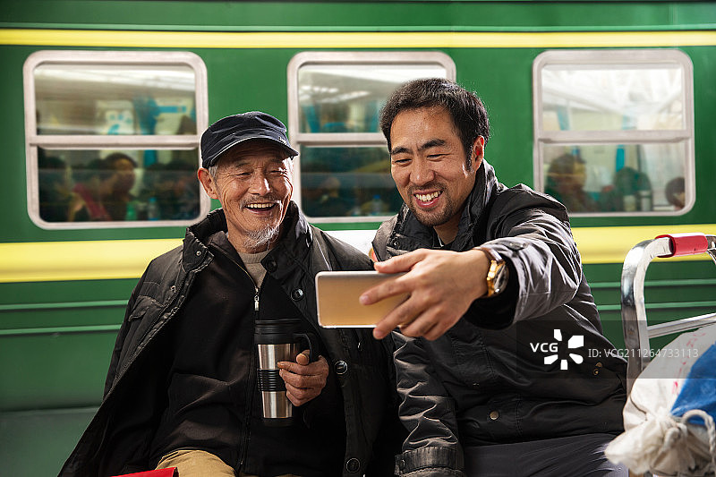 在火车站台上看手机的旅客图片素材