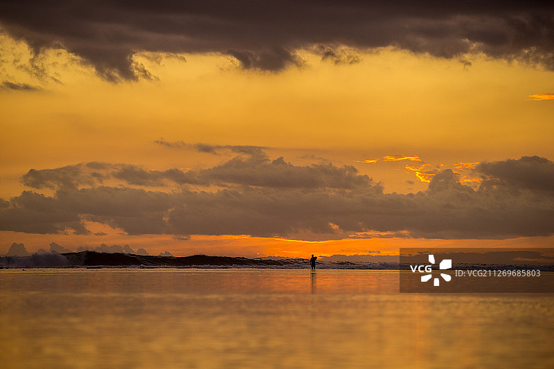 在日落的海上行走的人的剪影，小卡斯诺耶尔，毛里求斯图片素材