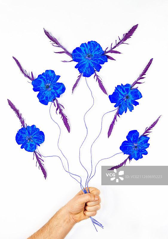 数字合成的人的手拿着弦与绘制的蓝色花图片素材