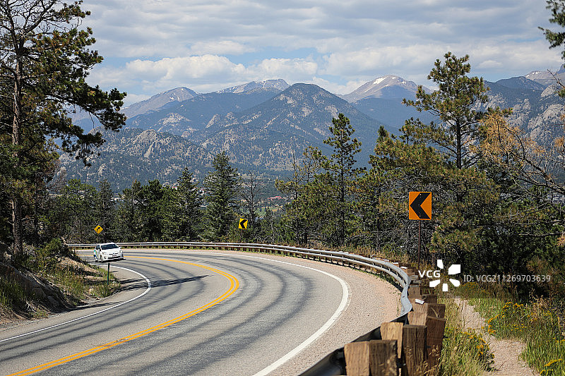 白色汽车在急转弯的道路上与地平线上的山脉图片素材
