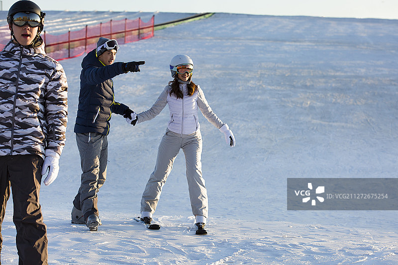 三个青年男女滑雪运动在户外滑雪场图片素材