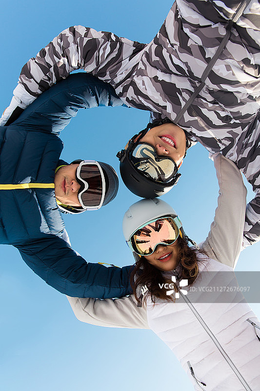 三个青年男女搂在一起加油在户外滑雪场图片素材