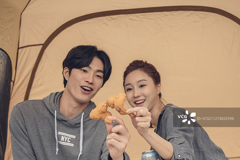 一对夫妇在邯钢公园的帐篷里吃鸡肉的照片图片素材