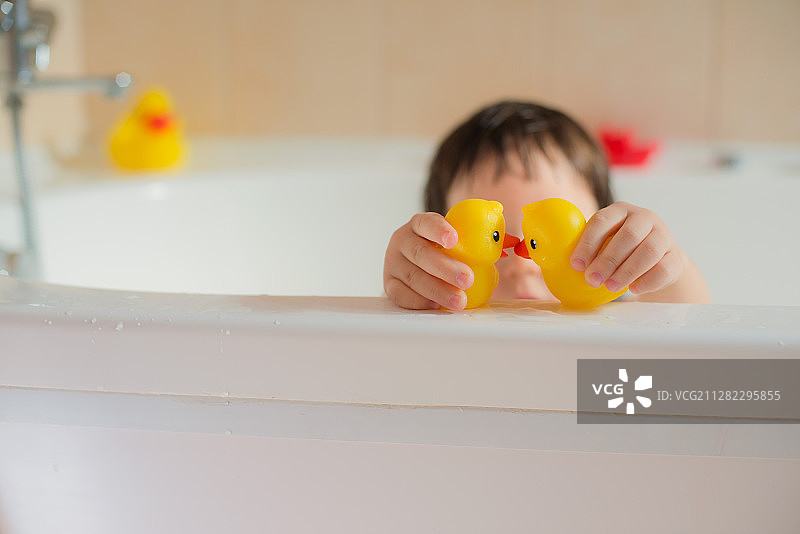 快乐的小婴儿在浴室玩橡胶黄点卫生和照顾年轻图片素材