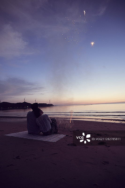 一对情侣坐在海滩上看天上的星星图片素材