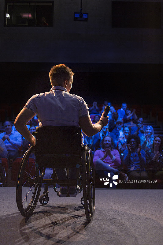 舞台上坐轮椅的女性演讲者图片素材
