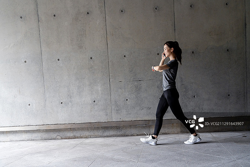 一名女性在城市建筑前锻炼图片素材