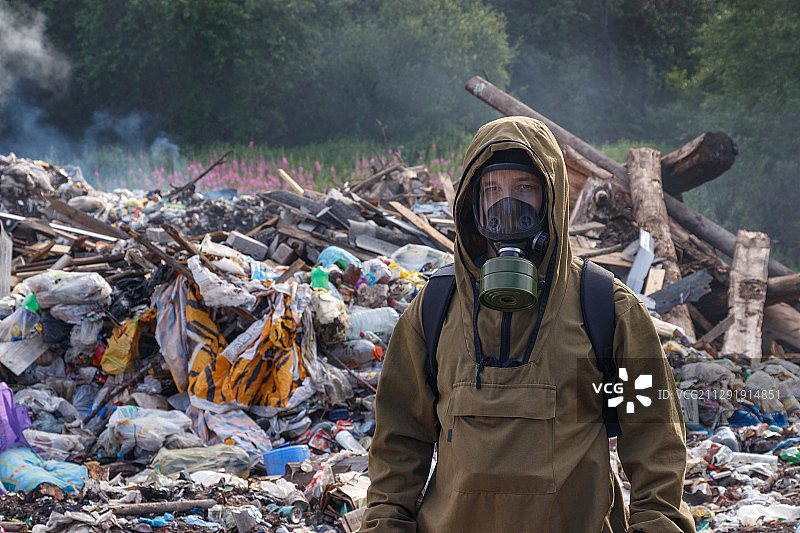 一个戴着防毒面具的男人在垃圾场的肖像图片素材