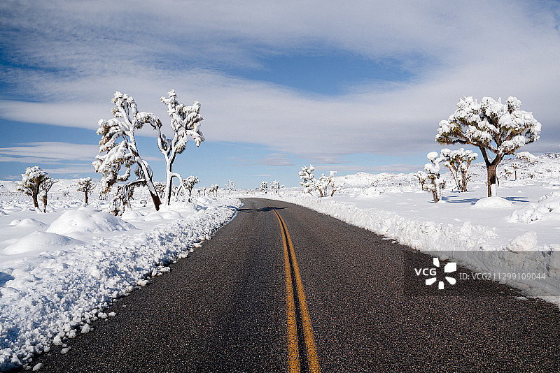 白雪覆盖的道路对天空的风景，二十九棕榈，美国图片素材