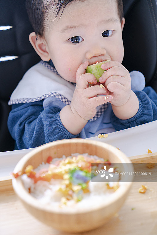 婴儿自己进食时的可爱表情图片素材