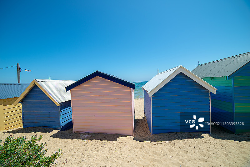 低角度的彩色阳伞在海滩上对抗清澈的蓝天，布莱顿，维多利亚，澳大利亚图片素材