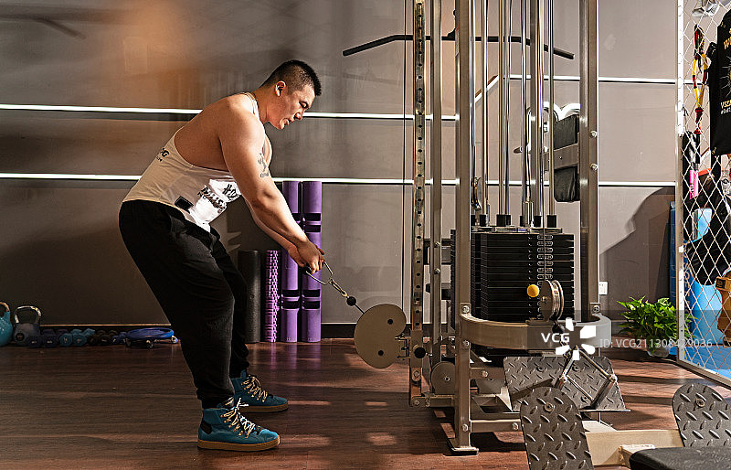 青年男子在健身房锻炼肌肉图片素材