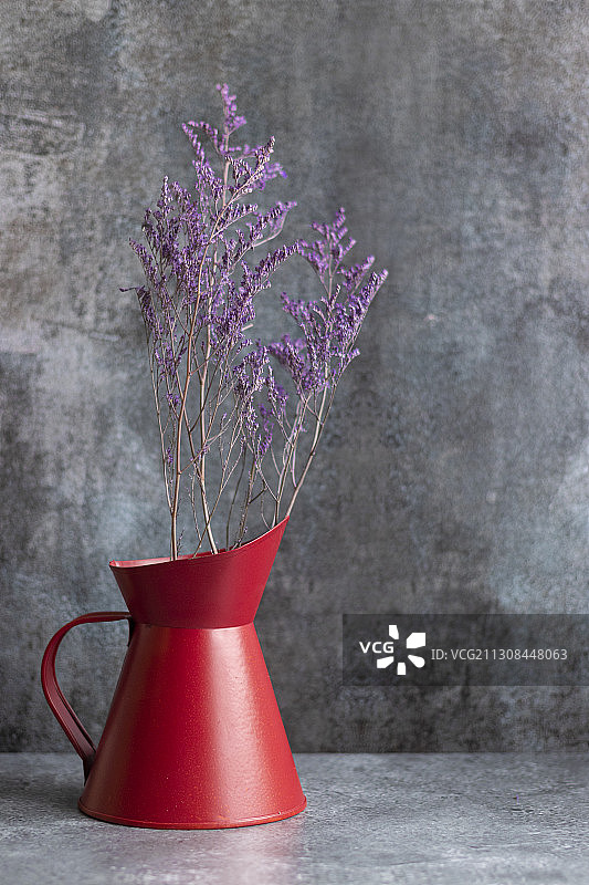 靠墙的桌子上的花瓶里的紫色花朵的特写图片素材