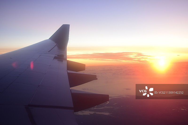 裁剪图像的飞机机翼在日落时飞过云景，新西兰图片素材