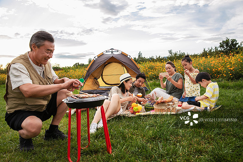 快乐家庭在郊外烧烤野餐图片素材