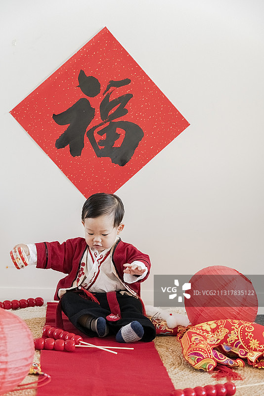 春节快乐地挥动冰糖葫芦串的红汉服男婴图片素材