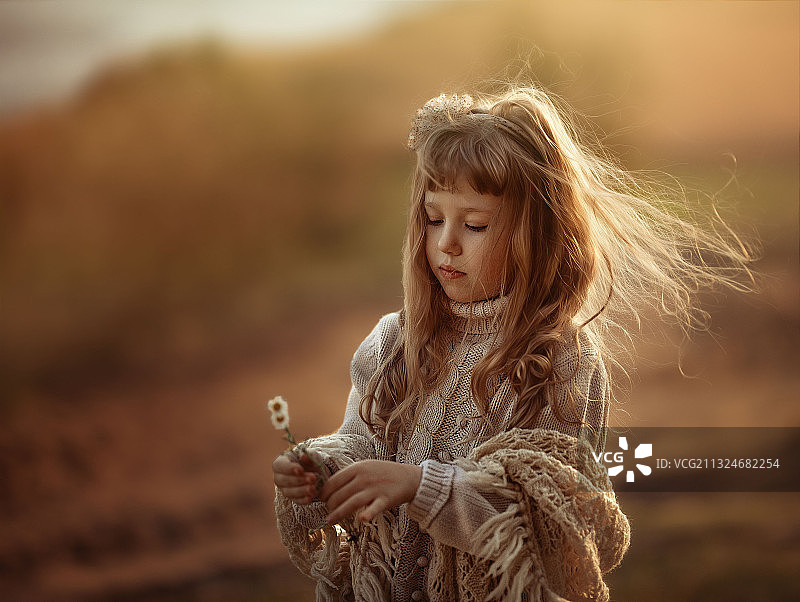乌克兰，女孩手捧鲜花，闭着眼睛站在田野上图片素材