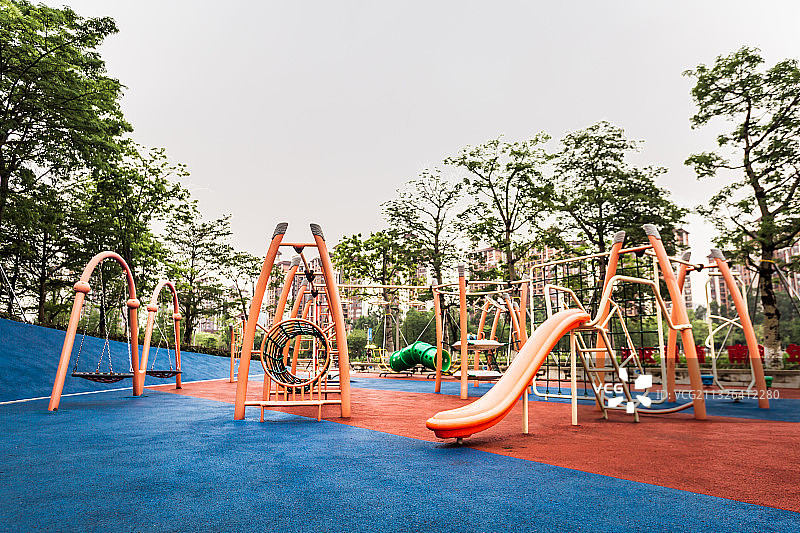 绿道公园儿童游乐区内的玩乐设施和红蓝配色的橡胶地板图片素材