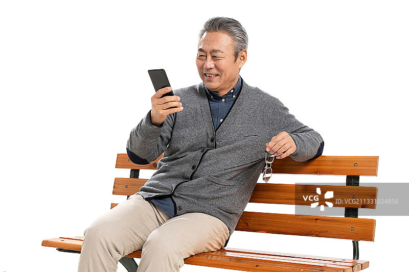坐在长椅上的老人看手机图片素材