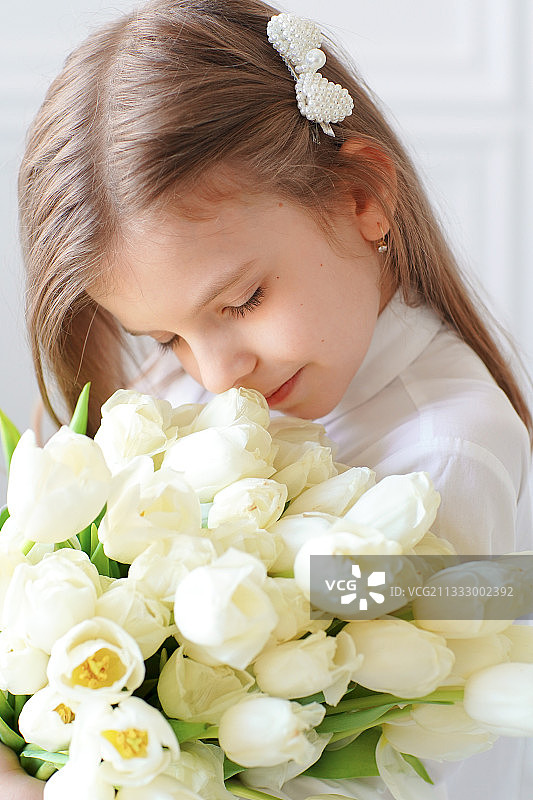 快乐的年轻女孩在家和郁金香图片素材