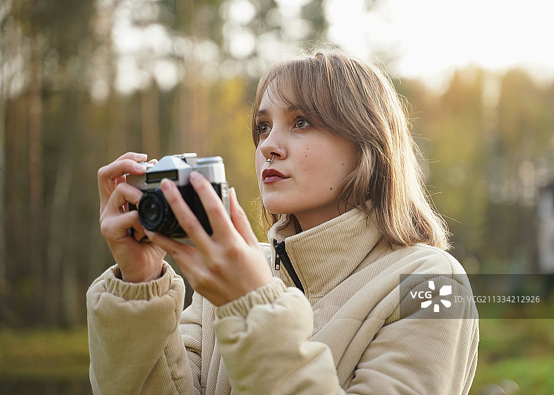 年轻女子在自然中拍照，俄罗斯图片素材