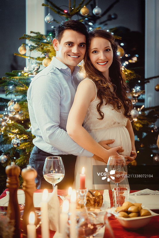 一对快乐的夫妇庆祝圣诞节，妻子怀孕了图片素材
