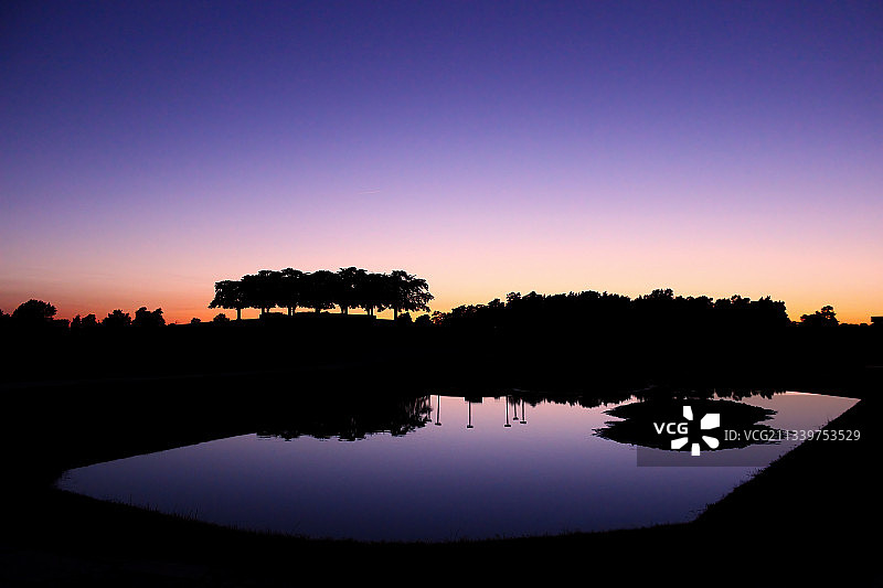 日落时分，瑞典斯德哥尔摩，湖边的树木的剪影图片素材