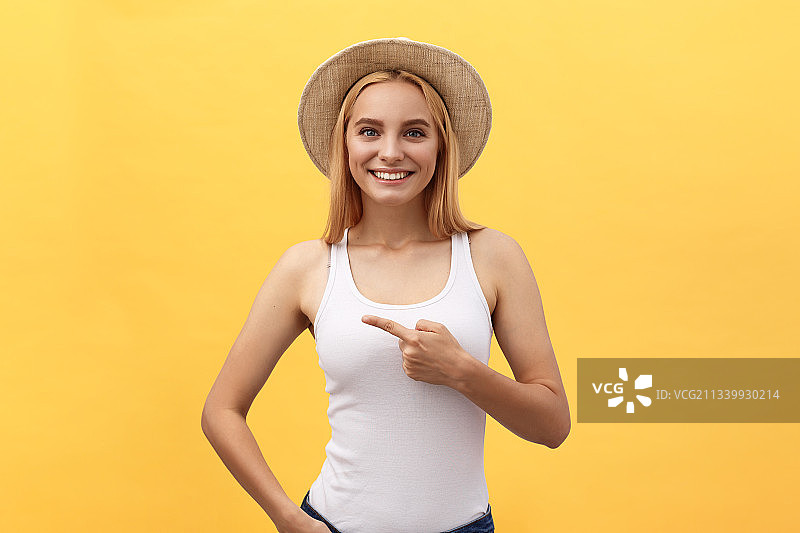 微笑的年轻女子站在黄色背景的肖像图片素材